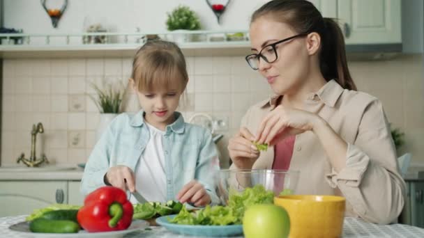 Mignon aimant fille aider mère avec salade alimentation jeune femme et rire — Video