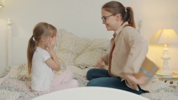 Mujer joven está dando regalo a la chica feliz y aplaudiendo las manos haciendo sorpresa a los niños — Vídeo de stock
