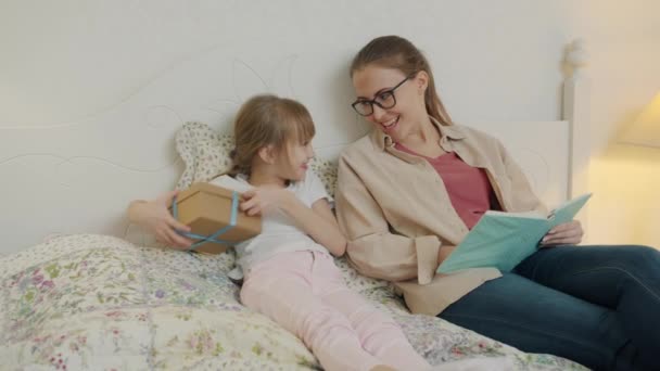 Fille aimante adorable enfant donnant cadeau à la mère heureuse, femme reconnaissante étreint fille — Video