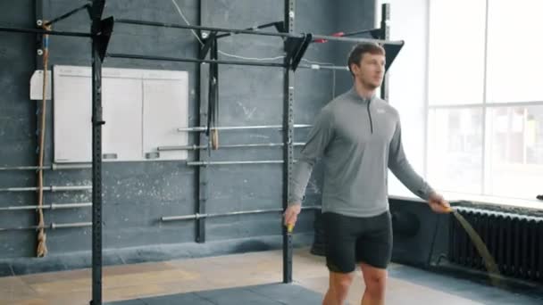 Підійде спортсмен, який пропускає зі стрибковою мотузкою у спортзалі, зосереджений на кардіо вправах — стокове відео