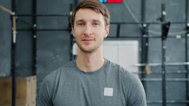 Slow motion portrait of handsome sporty guy in gym smiling and looking at camera alone — Stock Video