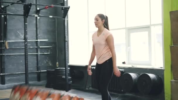 Mladá fit sportovkyně zvedání těžké gumy pneumatiky během crossfit cvičení uvnitř — Stock video