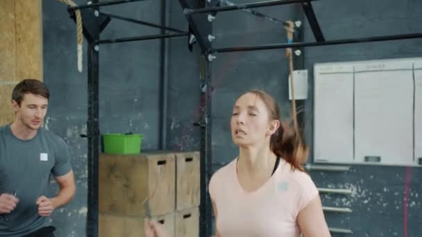 Trage beweging van vrouwelijke student springen in de sportschool met springtouw werken met trainer — Stockvideo