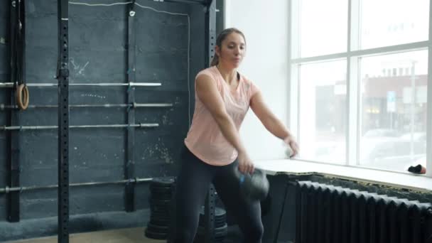 Spiersportvrouw training met kettlebell kraken en tillen gewicht in de sportschool — Stockvideo