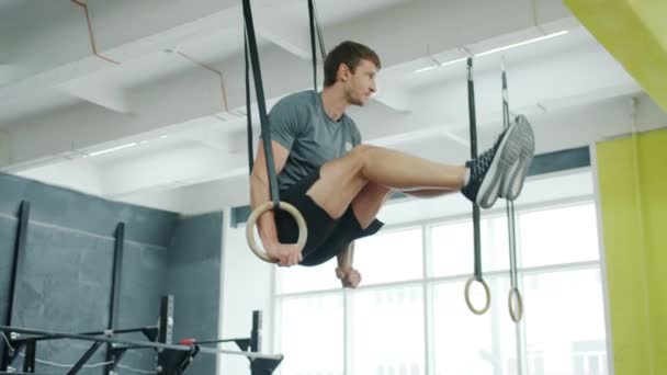 Movimento lento do cara se exercitando em anéis durante o treinamento intenso crossfit trabalhando sozinho — Vídeo de Stock