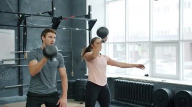 Kız ve erkek spor partnerleri spor salonunda birlikte spor yaparken ve ağırlık kaldırırken.