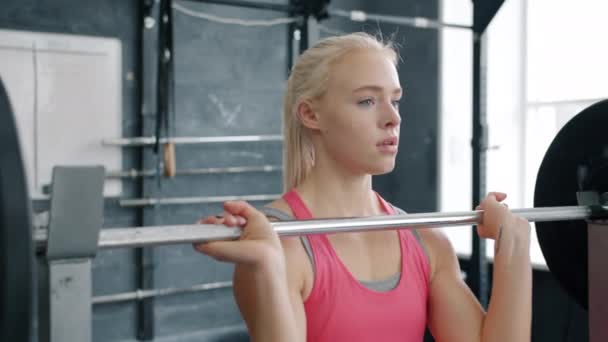Junge Frau beim Langhanteltraining im Fitnessstudio mit Spaß am Bodybuilding — Stockvideo