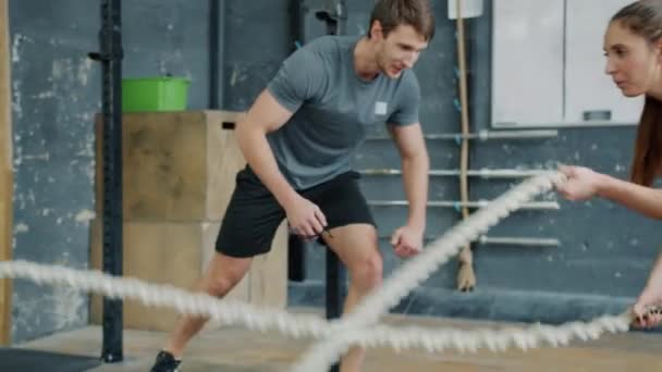 Zpomalený pohyb studentky cvičení z bojových lan, zatímco trenér motivující mluvení gestikulace — Stock video