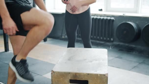 在体操馆进行交叉体能训练时，匿名男子跳到木箱上的低镜头 — 图库视频影像