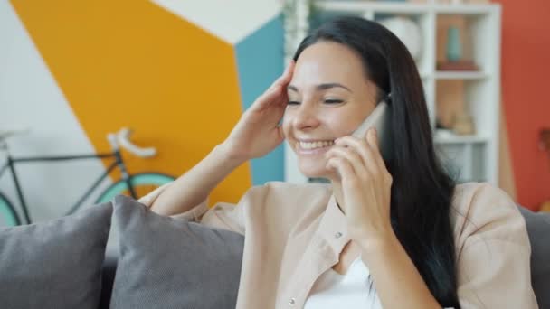 Cámara lenta de la mujer joven hablando en el teléfono móvil y riendo en casa — Vídeo de stock