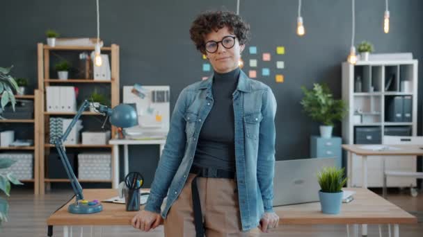 Portret van een vrolijke kantoormedewerker die alleen op kantoor staat en glazen aanraakt en glimlacht — Stockvideo