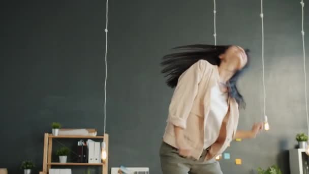 Грайлива бізнес-леді танцює на робочому столі в модному одязі, розважаючись на робочому місці — стокове відео