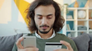 Apartman dairesinde akıllı telefon ve banka kartıyla nakit ödeme yapan neşeli bir Arap 'ın ağır çekim gücü.