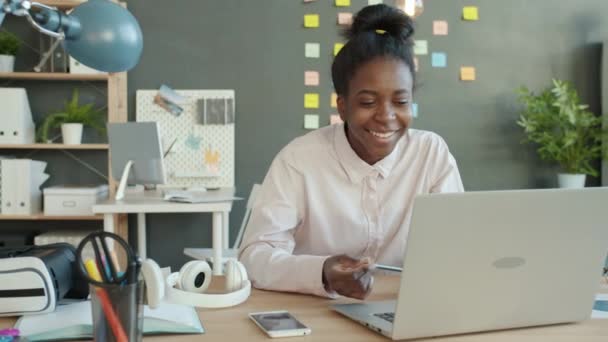 Empresária afro-americana fazendo videochamada online do local de trabalho conversando e gesticulando — Vídeo de Stock