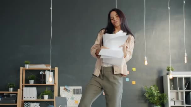 Happy office werknemer dansen op tafel gooien papieren genieten van muziek en vrijheid — Stockvideo