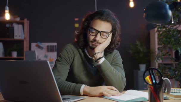 Zeitlupe eines arabischen Unternehmers, der im dunklen Büro schläft und dann aufwacht und mit dem Computer arbeitet — Stockvideo