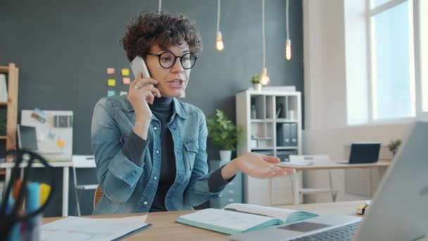 Ongelukkige zakenvrouw schreeuwt tegen zakenpartners met een telefoontje in het kantoor — Stockvideo