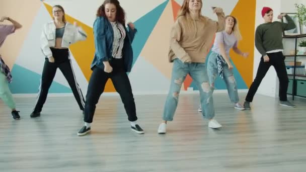 Χαμογελώντας κορίτσια και αγόρια που χορεύουν σε στούντιο χιπ-χοπ προπονούμενοι σε εσωτερικούς χώρους μαζί — Αρχείο Βίντεο