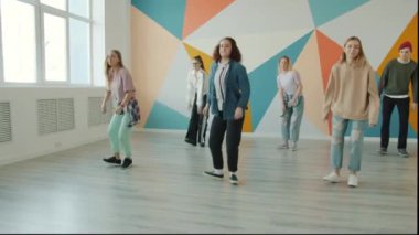 Dans salonunda dans eden mutlu genç insanlar, hareket eden bedenler ve gülümseyen