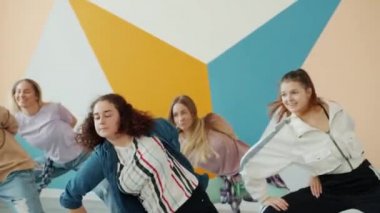 Modern sanat stüdyosunda dans eden yaratıcı genç kadınlar dans ediyorlar.