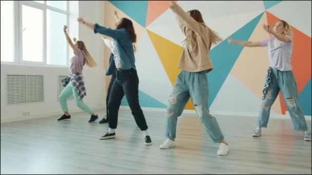 Grupa dziewcząt tańczących w nowoczesnym studio tańca bawiących się razem — Wideo stockowe