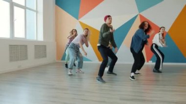 Bir grup dansçı erkek ve kadın modern dans salonunda dans ediyorlar.