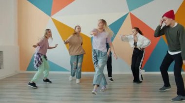 Neşeli genç dansçılar hip-hop stüdyosunda gösteri yapıyorlar.
