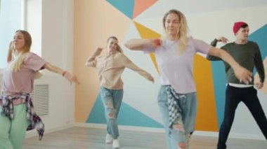 Modern dans stüdyosunda antrenman yapan yetenekli gençlerin yavaş çekimleri.