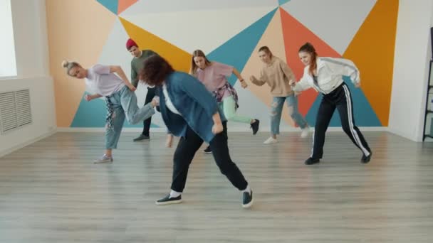 Insegnante di danza femminile che dimostra le mosse moderne al gruppo di giovani — Video Stock