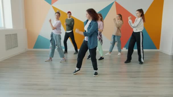 Groep studenten leren dansen beweegt van professionele danser vrouwelijke leraar in de studio — Stockvideo