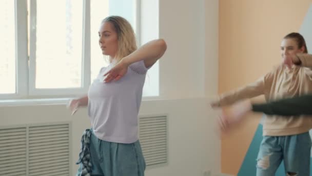 Jóvenes creativos aprendiendo movimientos de baile durante la clase de baile en estudio moderno — Vídeo de stock