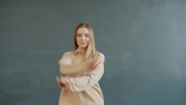 Ritratto di affascinante adolescente che danza in studio di danza muovendo le braccia guardando la macchina fotografica — Video Stock