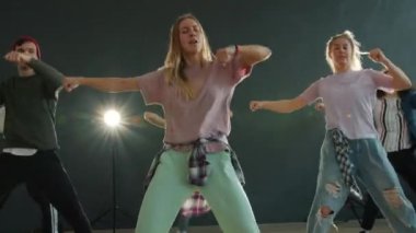 Sahnede dans eden aktif gençlere zum yap. Karanlık salonda, arka planda ışıklar olsun.