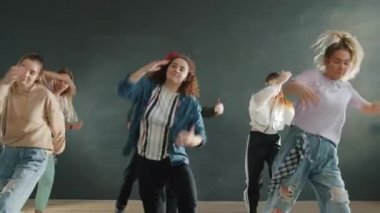 Dansçıların yavaş çekimde kapalı alanda birlikte müzik yapmaları.