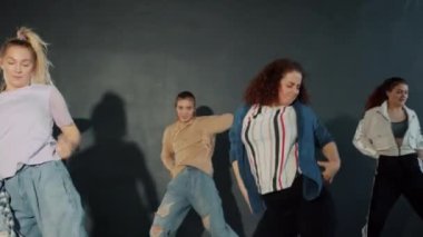 İç mekan performansı sırasında karanlık salonda dans eden yaratıcı gençlerin yavaş çekimi.