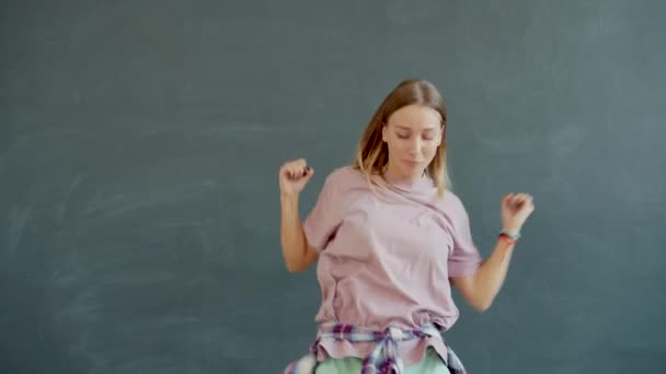 Powolny portret atrakcyjnej młodej blondynki tańczącej na szarym tle — Wideo stockowe