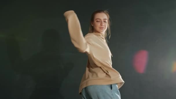 Талановита танцівниця, що виконує сучасний хіп-хоп танець у темному освітленому залі — стокове відео