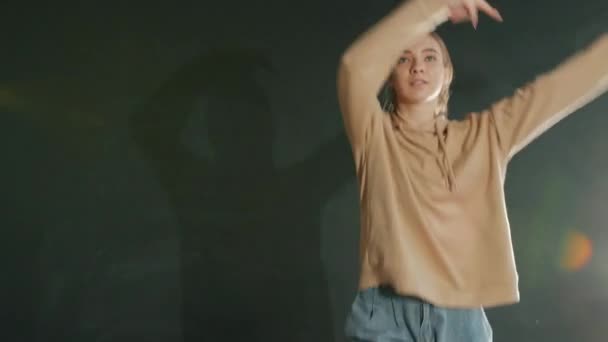 Portret ładnej nastolatki tańczącej w pomieszczeniu z bokeh lights na szarej ścianie w tle — Wideo stockowe
