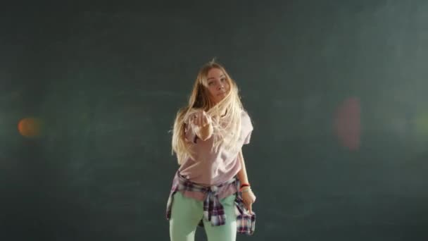 Chica creativa con pelo largo y rubio bailando en estudio de danza moderna en habitación oscura — Vídeo de stock