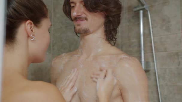 Onnellinen pari pesu suihkussa yhdessä nauttien vapaa-ajasta kylpyhuoneessa — kuvapankkivideo