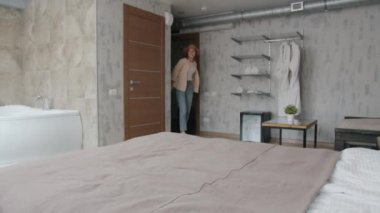 Kız ve bavullu adam otel odasına giriyor ve sonra yatakta dinleniyor.