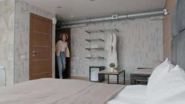 Otel süitine giren iki turist öpüşüp kucaklaşarak yatağa torba koyuyor.