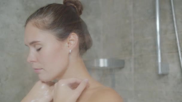 Långsam rörelse av attraktiv flicka rengöring hud i dusch tvätt med skum ensam — Stockvideo