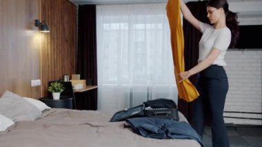 Güzel bir kadın bavulunu hazırlayıp otel odasından çıkıyor ve tatili bitiriyor.