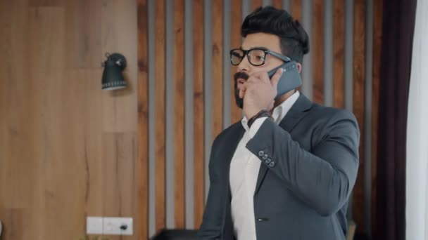 Ambitious Middle Eastern businessman making mobile call from hotel room — Stock Video