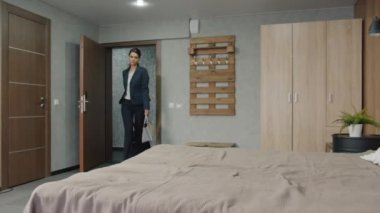 Yorgun iş kadını otele geliyor. Odaya giriyor. Yatakta dinleniyor.