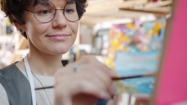 Potret seniman wanita muda yang cantik melukis gambar di dalam ruangan di studio kreatif — Stok Video