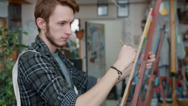 Zoom-out portrait des élèves de l'école d'art homme et fille dessin en classe occupé par l'activité créative — Video