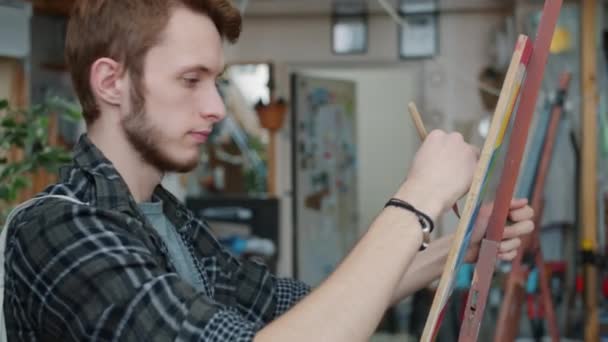 Couple of arts students drawing during lesson in craft school under guidance of male teacher — Stock Video