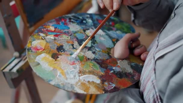 Detailní záběr Man ruční umělec míchání barev na paletě pak malování obrázku — Stock video